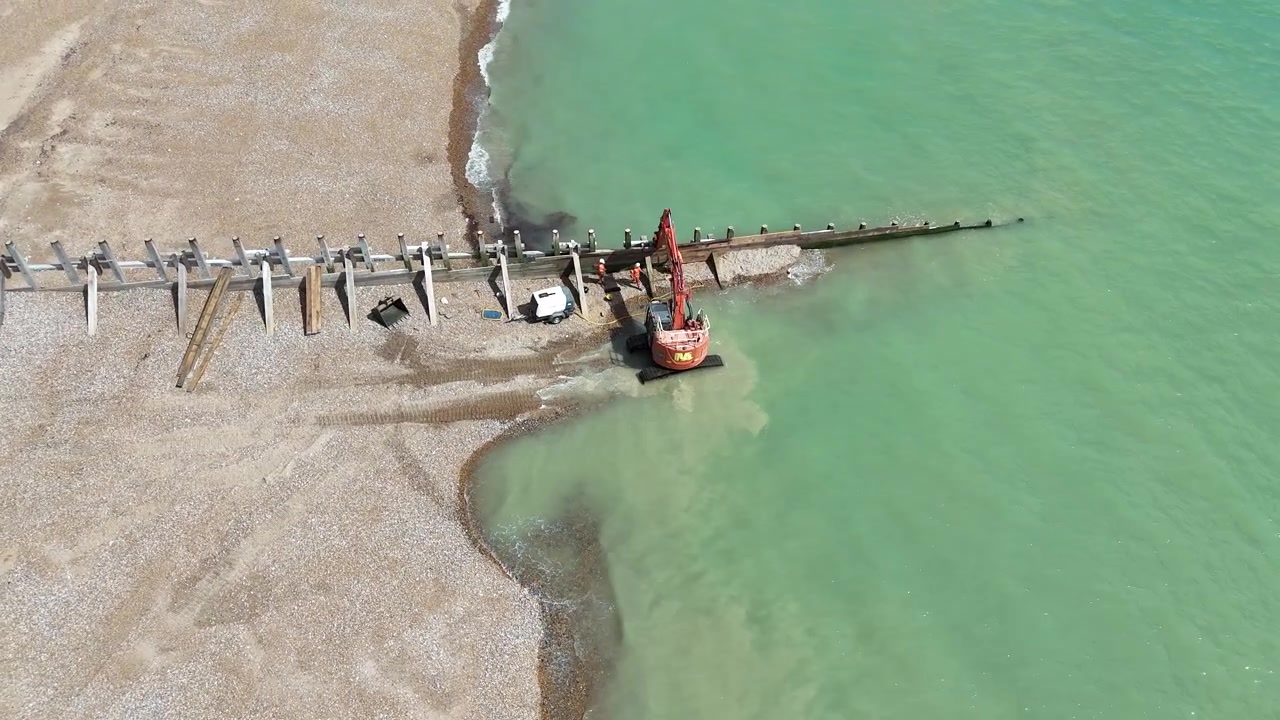 Hove, East Sussex, Regno Unito, agosto 2026 – Le riprese aeree con drone rivelano il nuovo campo di pennelli frangiflutti in legno costruito per ampliare la spiaggia e proteggere la costa dall'erosione e dalle inondazioni