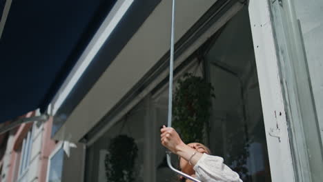 closeup woman open awning roof in flower city shop. start local business concept