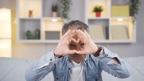 hombre haciendo una señal de corazón a la cámara.