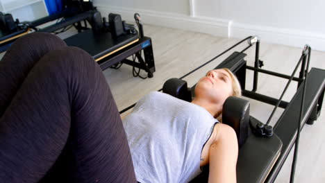 woman doing exercise with resistance bands on rowing machine 4k