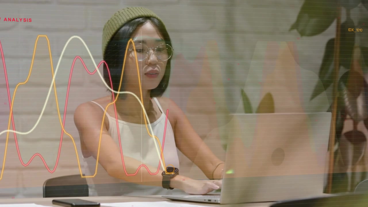 Woman ending call, placing phone, leaning to laptop, typing for business while graphs overlaying