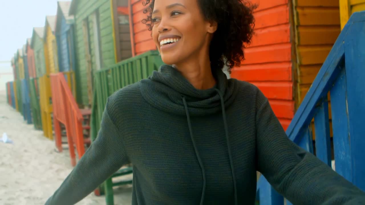 Young African american woman walking at beach hut 4k