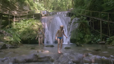 family enjoying a waterfall in a forest