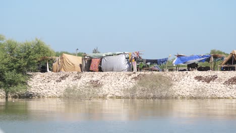 view of makeshift camps seen from across river in sindh, pakistan