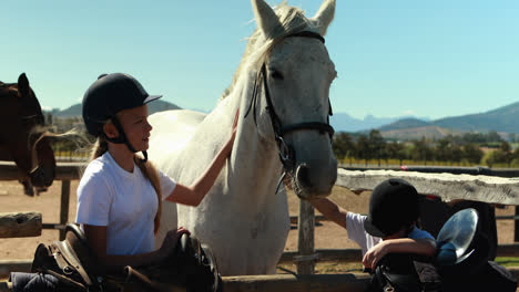 Siblings-touching-the-white-horse-in-the-ranch-4k