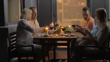 family having supper on outdoor house terrace