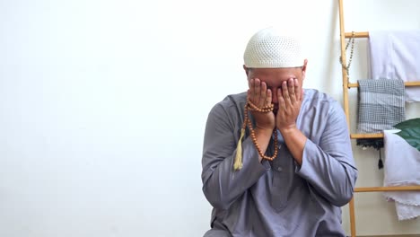 indonesian muslim man praying with hands raised and reciting dua