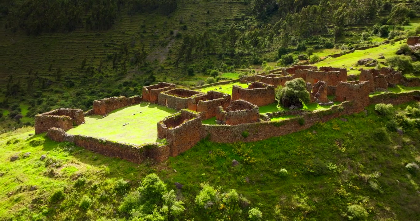 Antico sito archeologico Inca di Pumamarka, con rovine in pietra su un versante verde nella Valle Sacra, Perù. Drone aereo in orbita