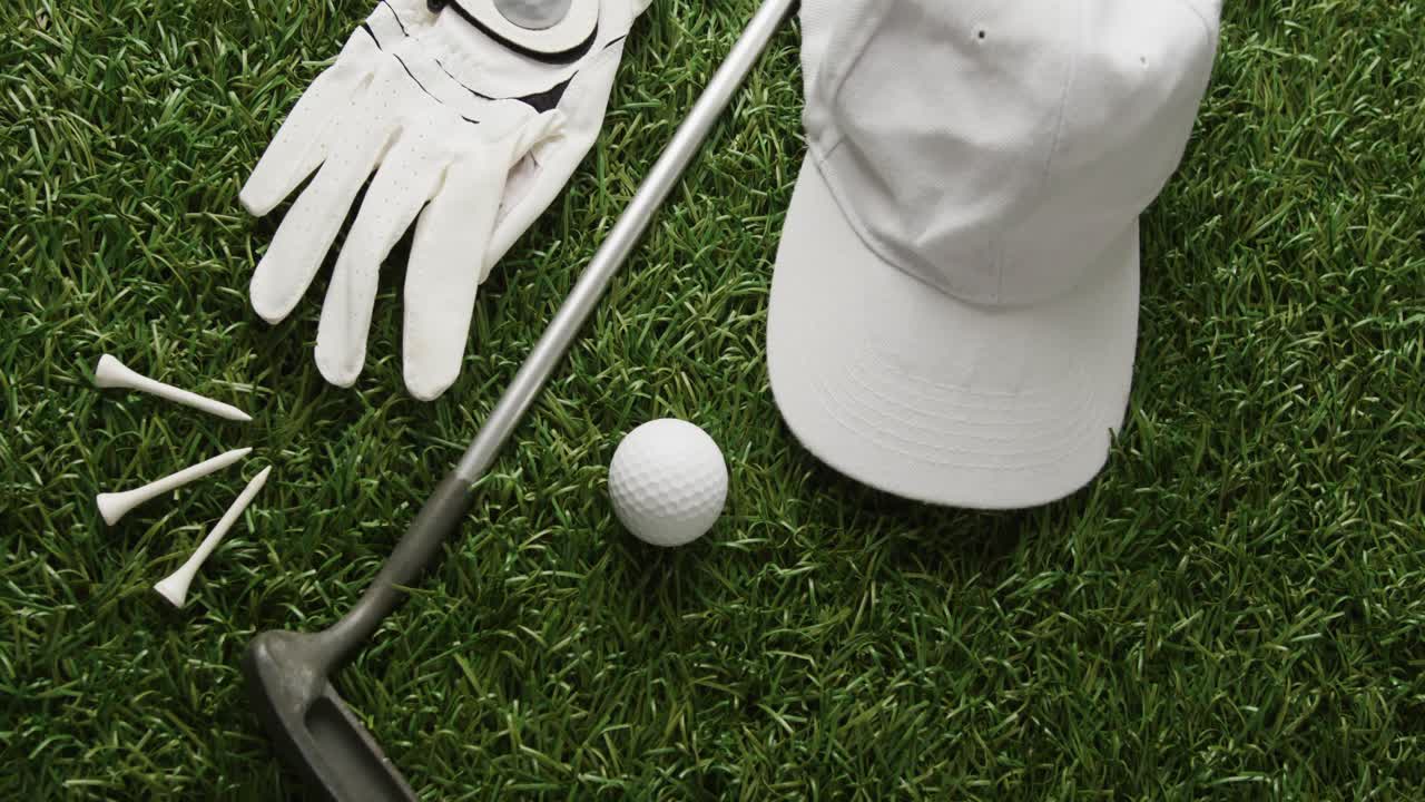 Primo piano di mazza da golf, pallina, guanto e berretto con visiera sull'erba, spazio per il testo, rallentatore