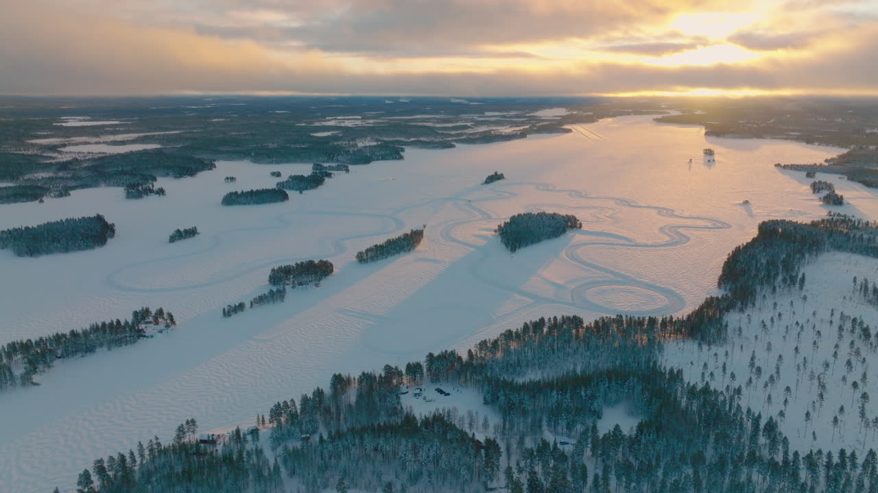 Gyllene snöig soluppgång, långa skuggor över Lapplands driftingbana, panoramisk flygvy