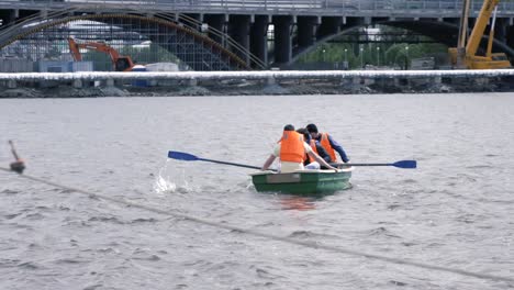 personas remando un bote en un río cerca de un sitio de construcción