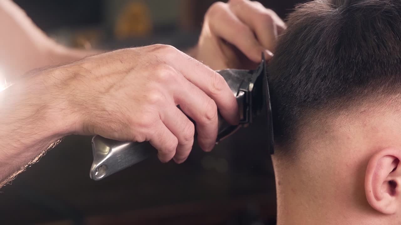 primo piano del taglio di capelli maschile nel negozio di barbiere