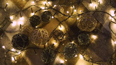 close-up christmas garland and handmade balls on a playd with golden lights. christmas concept. home decor