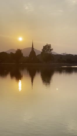 sunset silhouette of sukhothai thailand historical park, ancient ruins pagoda and temple buddhist cultural unesco heritage vertical