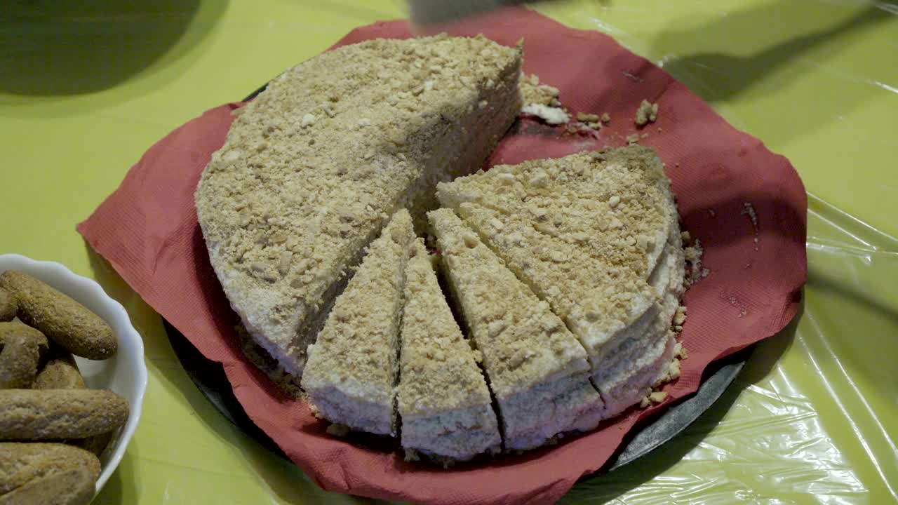 mamá pone en los platos pedazos de pastel cortado y los trata a los niños. celebración familiar. primer plano. la vista desde arriba. 4k.