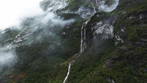 Luftbild-Mit-Parallaxe-Nach-Oben,-Der-Wasserfall-Fällt-Zwischen-Den-Wolken-Herab