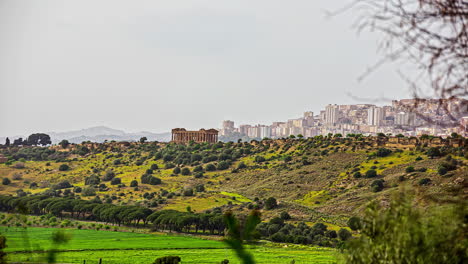 Statische-Aufnahme-Des-Tempels-Von-Segesta-Von-Einem-Entfernten-Standort-Mit-Sträuchern-Und-Grüner-Landschaft-In-Der-Ferne