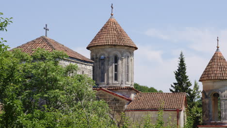 Motsameta-monastery-church-towers-towering-above-leafy-forest,-Georgia