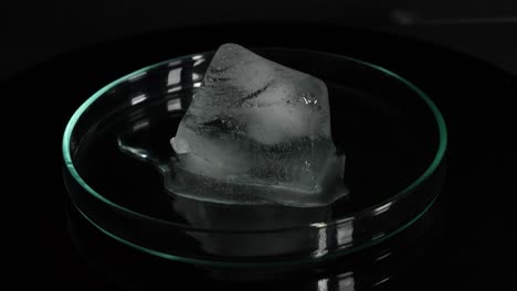 sequential frames showing ice melting in a glass dish