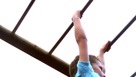 Boy-playing-on-monkey-bars-in-playground