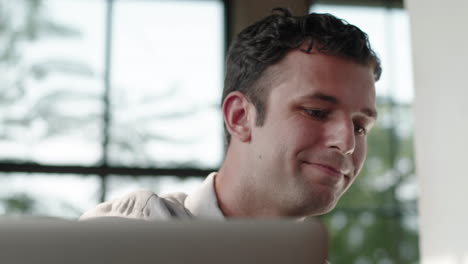 Man drinking matcha latte while working on laptop