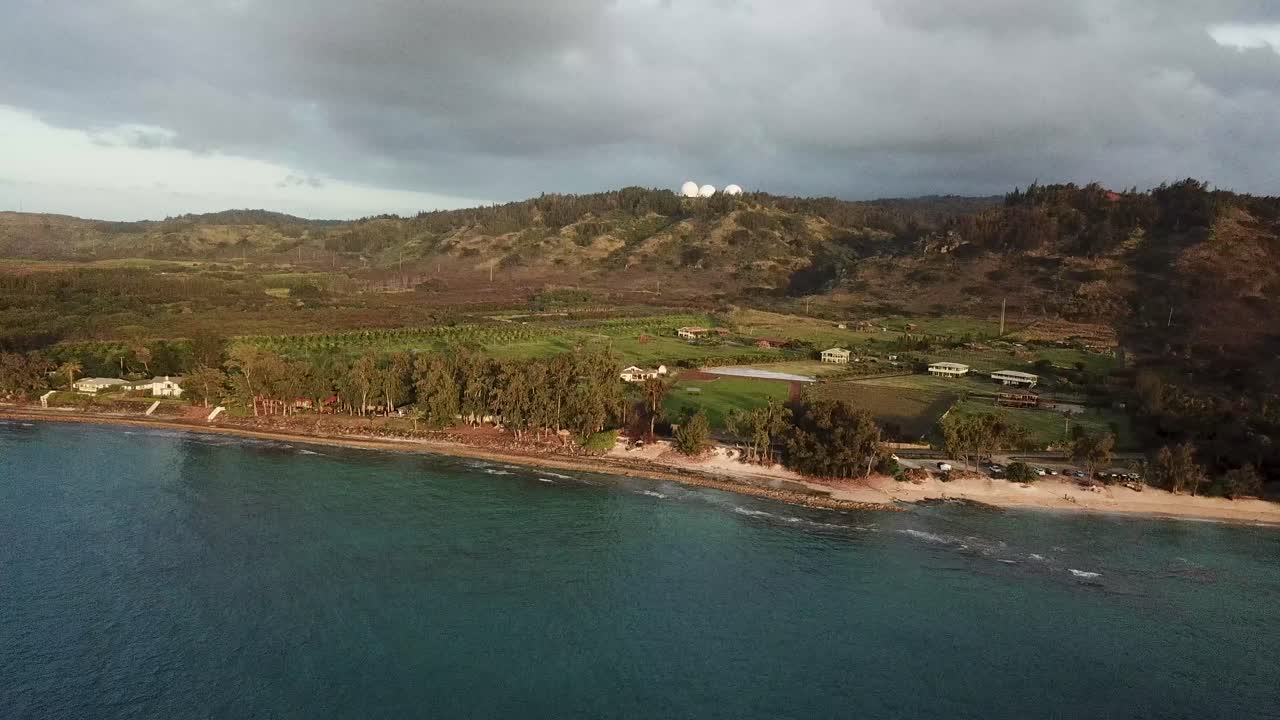 Vista aerea di Kawela Beach a Oahu, nelle Hawaii, che mostra una costa frastagliata, calme acque oceaniche blu e rigogliose colline sotto nuvole malinconiche. Serena scena tropicale del litorale