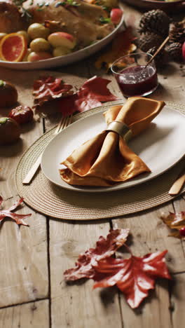 video vertical de pavo asado, platos y mesa con decoración de otoño