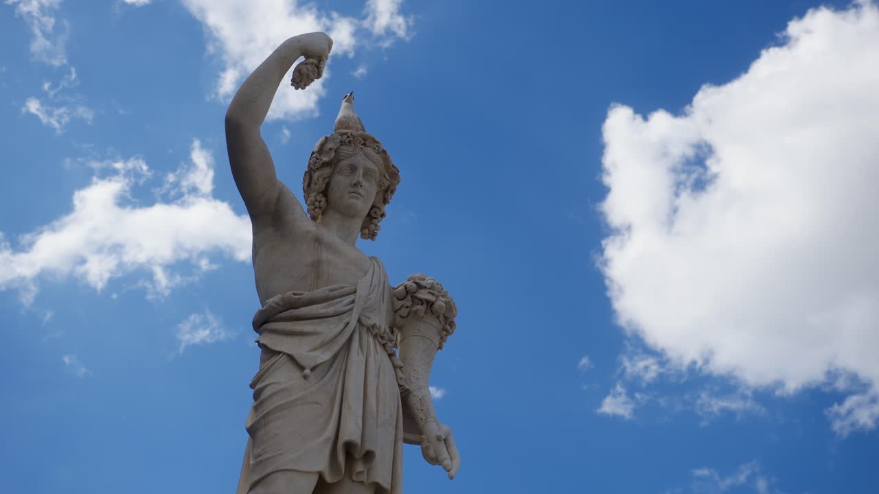 Low angle view of Roman statue with pigeon on head and moving clouds in Rome Italy Roma Italia