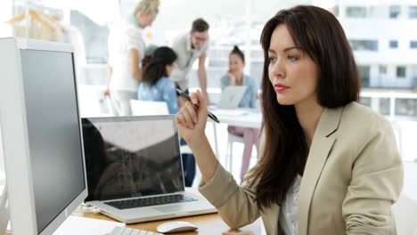 Mujer-Trabajando-En-Su-Escritorio-Y-Sonriendo-A-La-Cámara