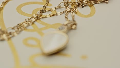 focus pull to a beautiful locket decorated with diamonds on a golden chain