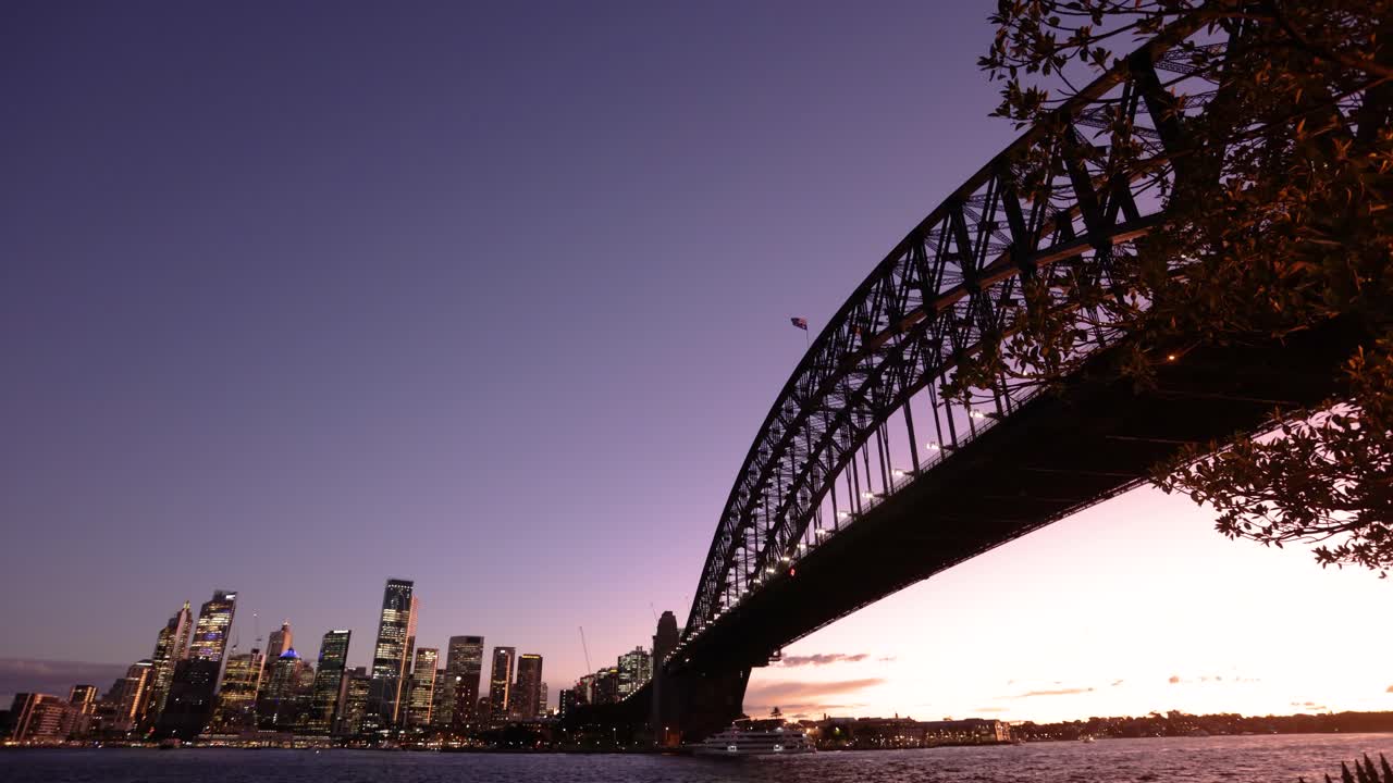 Wide angle view of Sydney city and the Harbour Bridge at sunset from Milsons Point.
