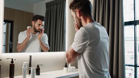 hombre lavándose la cara en el baño
