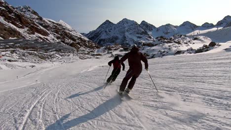 syncron ski turns of two male ski athletes on a beautiful panorama ski slope with great style and elegance