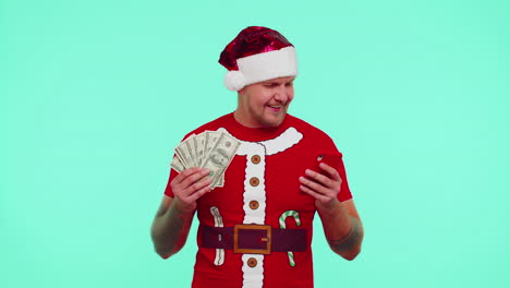 Man-in-Christmas-t-shirt-looking-smartphone-sincerely-rejoicing-win-success-luck-receiving-money