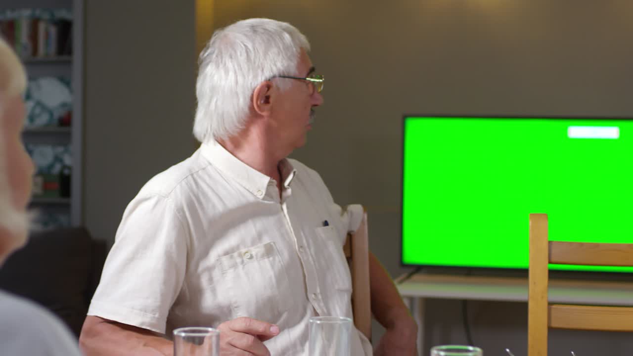 Elderly Couple Watching TV at Dinner