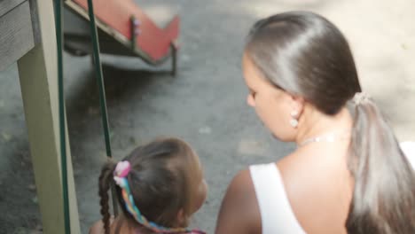 madre y hija embarazadas jugando en el columpio al aire libre