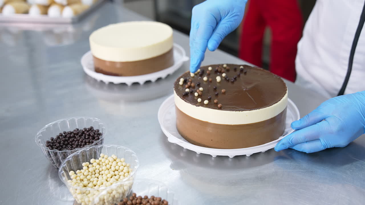 Chocolate, cocoa and milk dragee candies are put on top of the cake. Tasty cakes are decorated with little sweet peas. Close up.