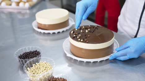 chocolate, cocoa and milk dragee candies are put on top of the cake. tasty cakes are decorated with little sweet peas. close up.