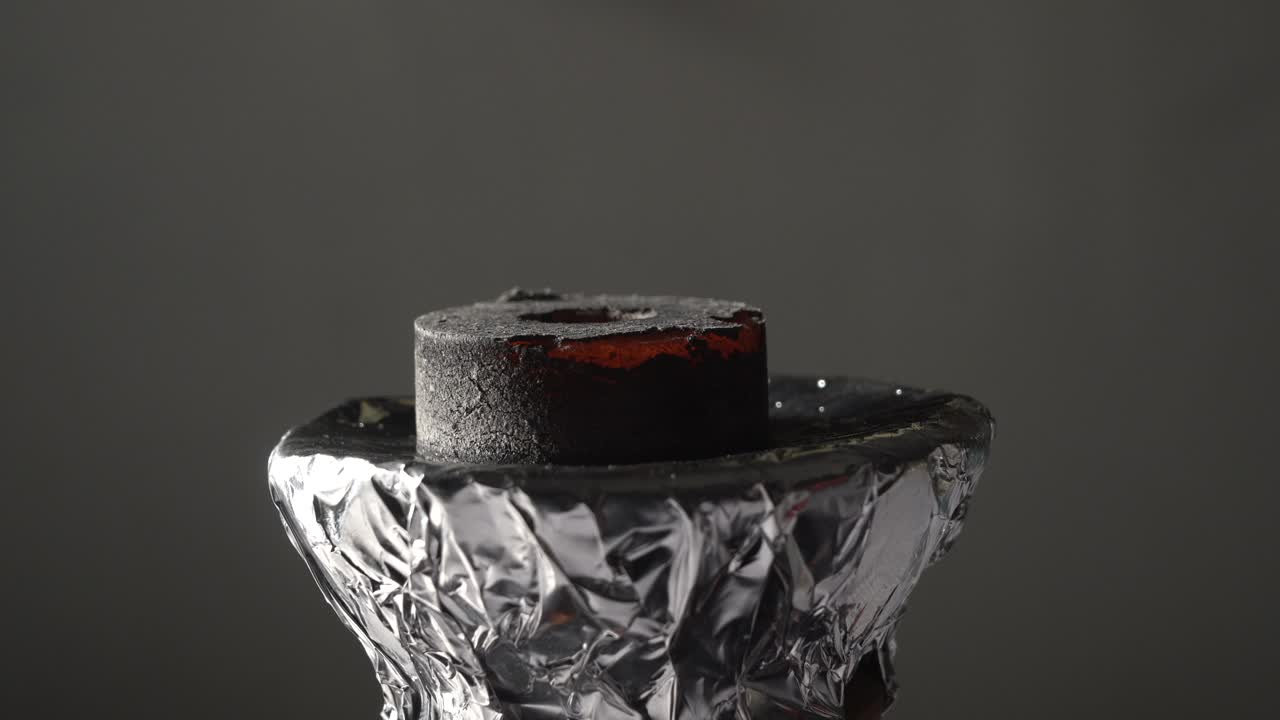 narguile poniendo carbón quemando rojo en la narguile