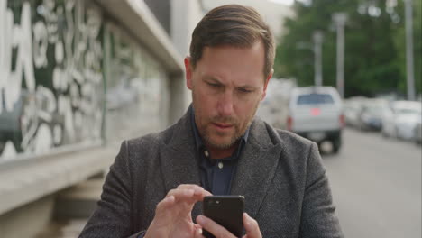 Retrato-De-Un-Hombre-De-Negocios-Enviando-Mensajes-De-Texto-Navegando-Usando-Tecnología-Móvil-De-Teléfono-Inteligente-Que-Parece-Enfocado-Esperando-En-Un-Restaurante-Urbano-Exitoso-Establecimiento-De-Redes-De-Empresarios-En-El-Teléfono-Móvil