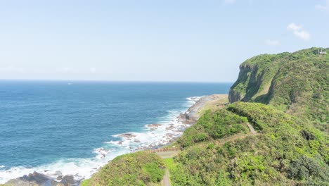 Timelapse-of-Cliff-and-Nature-waves,-ocean-and-Rocks-Formations-Keelung-Wangyou-Valley-Taiwan,-overlooking-South-China-Sea-and-fisherman-boats-passing-by