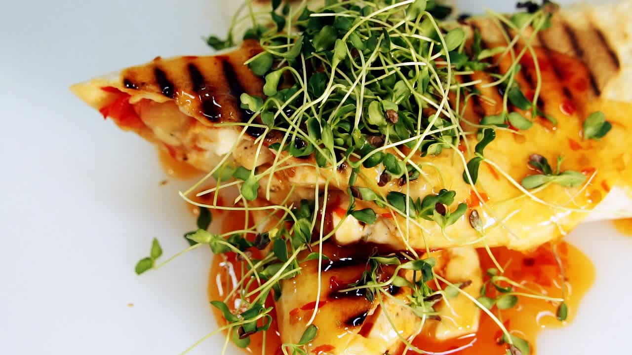 Mouth-watering meal rotating on table. Yummy appetizer with green sprouts. Tasty pita cooked on grill decorated with green. Close-up