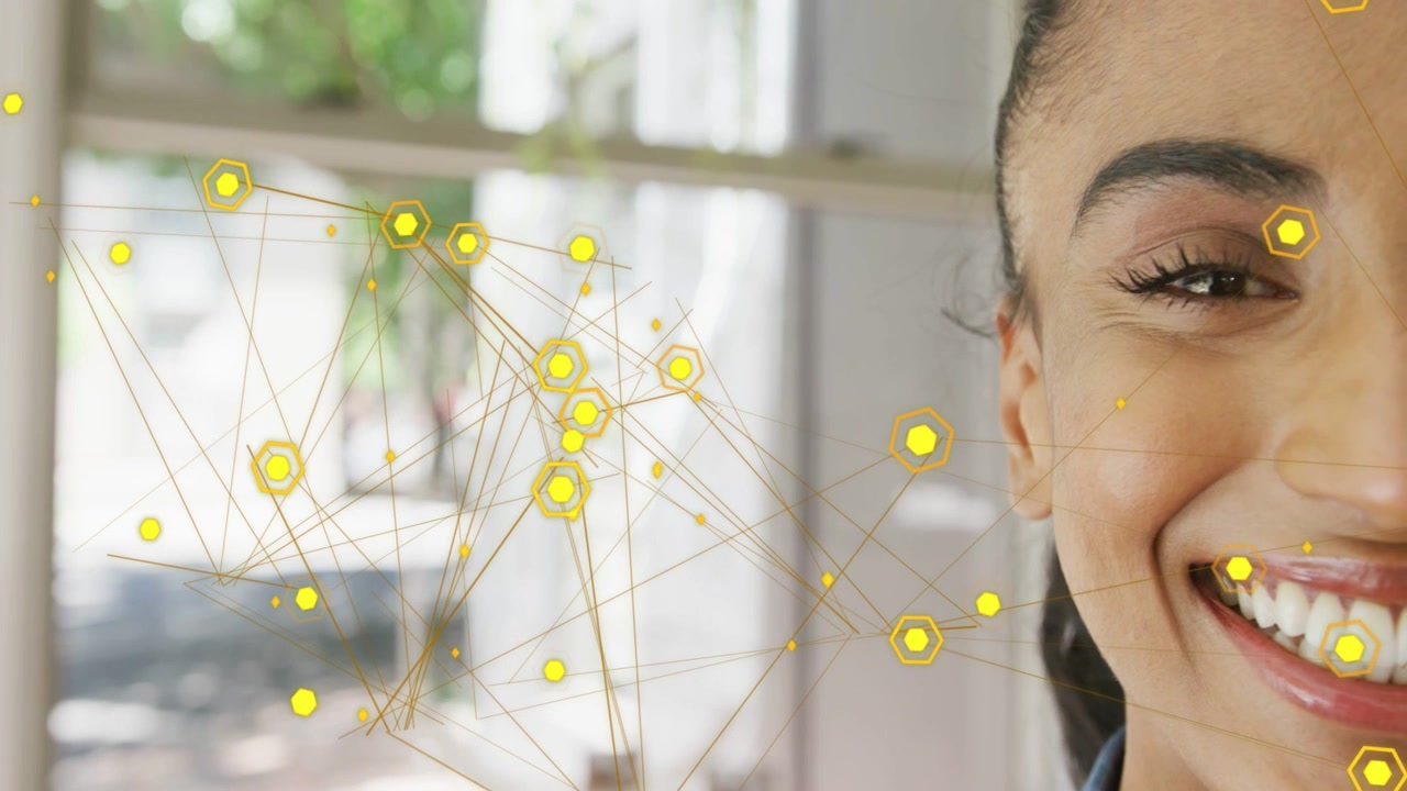 Woman smiling on-camera in tech demo, overlay pulsing, yellow hex nodes shifting, highlighting face