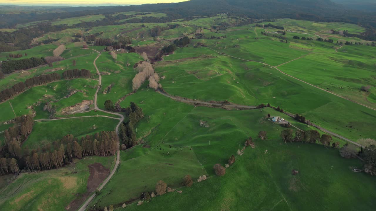 Scenic aerial view of green fields and rural roads in a countryside, landscape with farm buildings