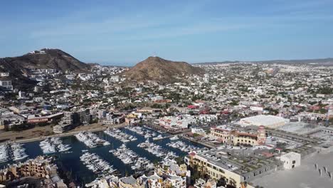 a sliding view of the cabo san lucas marina with surrounding cityscape