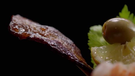 un pedazo de tocino cae grasa colgando de una bebida
