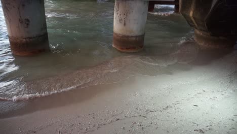 waves crashing under pier - beach chill relax