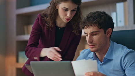 woman supervisor helping colleague man working together at workplace close up.