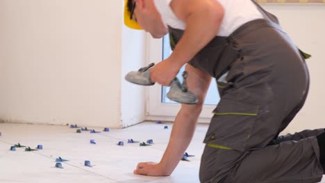 the tiler installs tiles on the floor repairing the interior of the house