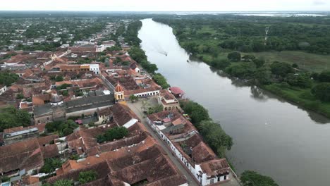 aerial of santa cruz de mompox colombia colonial style little town village in bolivar department drone above city center with church and river magdalena